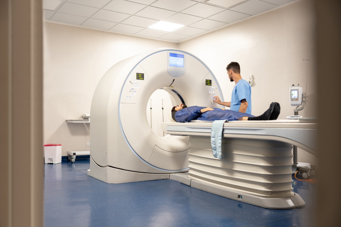 Imaging tech helping patient into a CT Scan