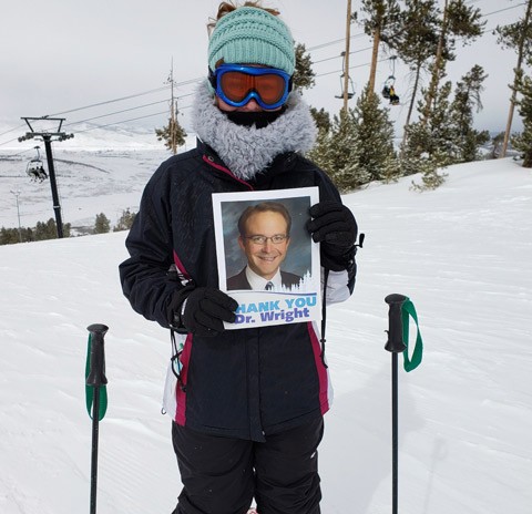 Aubrey Zechmann skiing with a photo of Dr. Wright