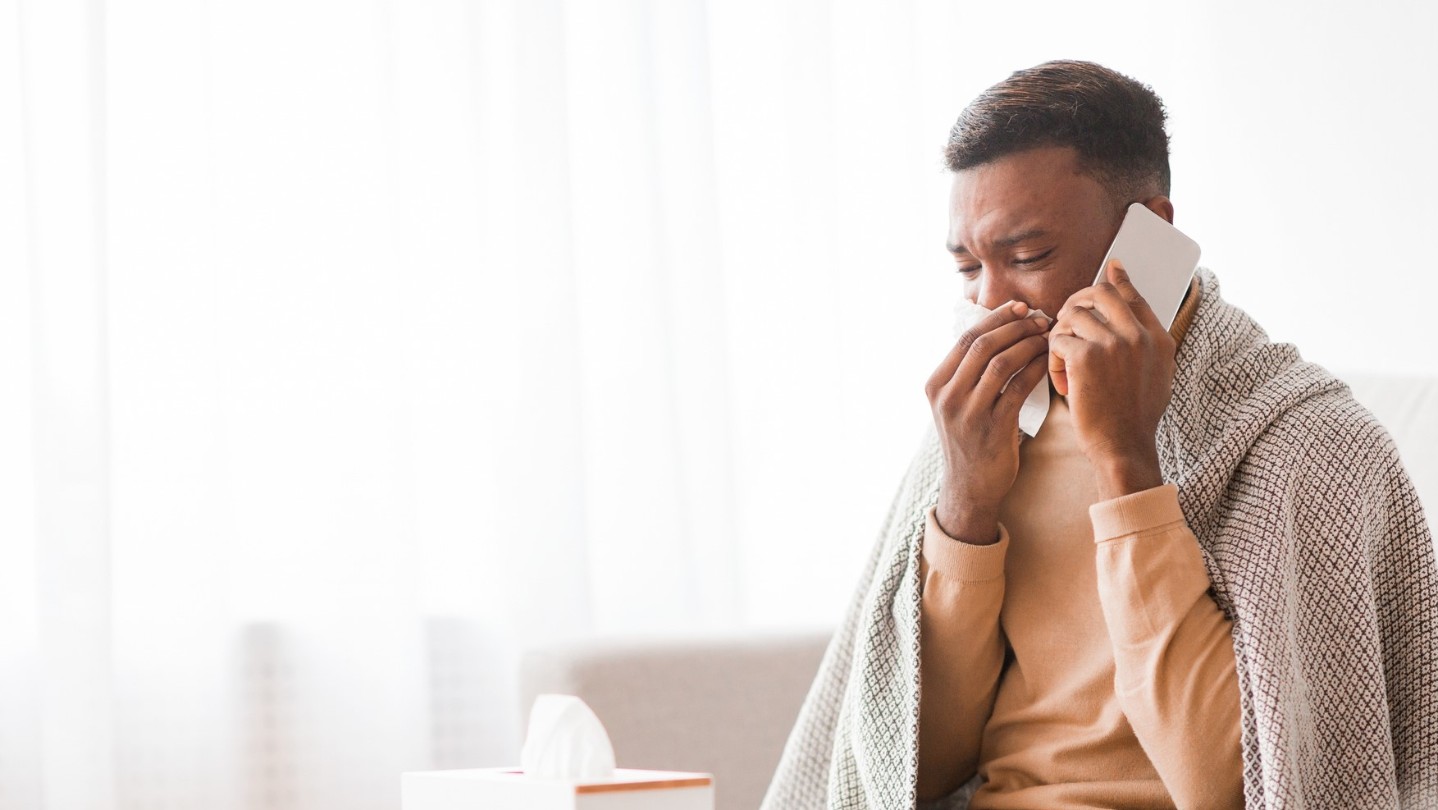 African American man with a cold and on his cell phone