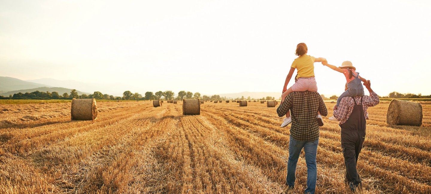 family walking in hay field